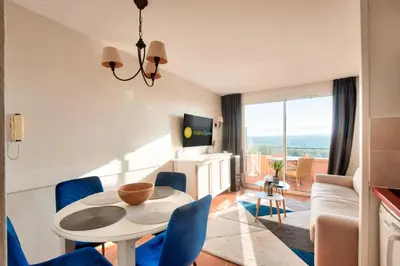 a living room with a table and blue chairs at Village Pont Royal en Provence - maeva Home - Appartement climatisé 2 pièces 4 personnes - Sélection MAE-2601 in Mallemort