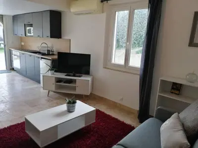 a living room with a couch and a tv and a table at Joli studio calme et moderne in Pertuis