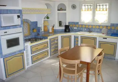 a kitchen with a wooden table and chairs in it at Provence Vaucluse Ventoux Villa Caromb in Caromb