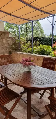 a wooden table with a vase of flowers on it at Bastide le Seigneur in Sault-de-Vaucluse