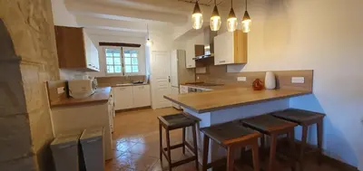a kitchen with a counter and stools in it at Bastide le Seigneur in Sault-de-Vaucluse