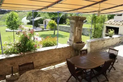 a patio with a table and chairs and a fountain at Bastide le Seigneur in Sault-de-Vaucluse