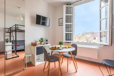 a dining room with a table and chairs and a window at Studio calme et lumineux in Aix-en-Provence