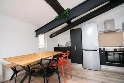 a kitchen with a wooden table and chairs and a refrigerator at Moderne et lumineux - clim - wifi in Aix-en-Provence