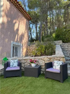 two chairs and a table in a yard at T3 avec jardin et piscine privée in Velaux