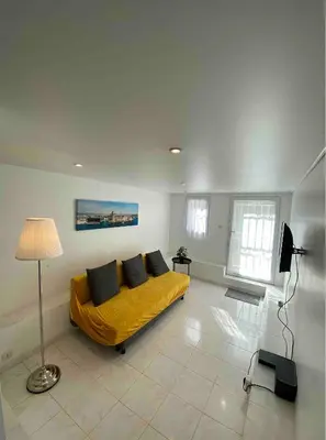 a bedroom with a bed with yellow sheets and a lamp at T3 avec jardin et piscine privée in Velaux