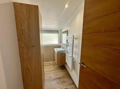 a bathroom with a wooden door and a sink at Ô Sorgue in LʼIsle-sur-la-Sorgue