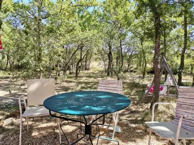 a picnic table and chairs in the woods at Luberon : maison près de Joucas et Gordes in Joucas