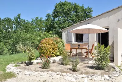 a patio with a table and an umbrella at Gite Hardy in Velleron