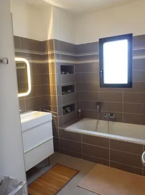 a bathroom with a tub and a sink and a window at 3 bedrooms new house with heated swimming pool in Carpentras