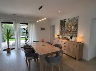 a dining room with a wooden table and chairs at 3 bedrooms new house with heated swimming pool in Carpentras