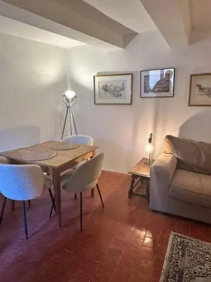 a living room with a table and a couch at Appartement centre village in Roussillon