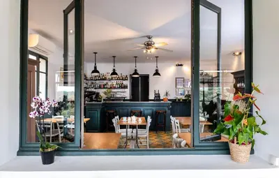 a dining room with a table and a bar at Hôtel Restaurant Les Remparts in Venasque