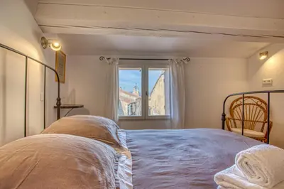 a bedroom with a bed and a window at Hôtel Restaurant Les Remparts in Venasque