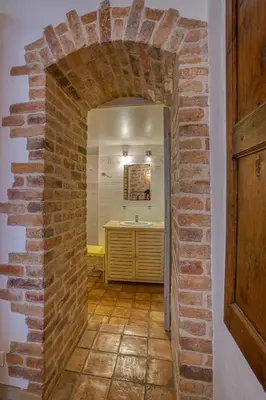 a bathroom with a brick wall and a sink at Hôtel Restaurant Les Remparts in Venasque