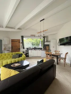 a living room with a couch and a table at Le p’tit bonheur-Piscine chauffée-clim-Park in Carpentras