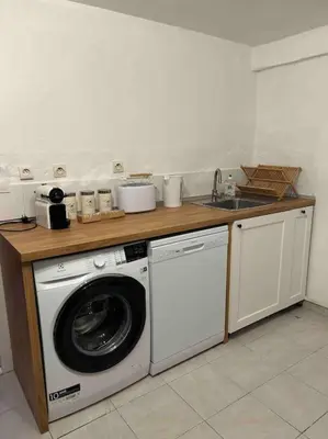 a kitchen with a washing machine and a sink at Soleil d’ocre - Bastide à Roussillon in Roussillon