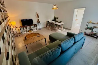a living room with a blue couch and a table at Soleil d’ocre - Bastide à Roussillon in Roussillon