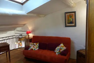 a living room with a red couch in a room at Au Bregnat Vue du mont Ventoux in Bédoin