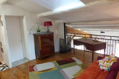 a living room with a couch and a piano at Au Bregnat Vue du mont Ventoux in Bédoin