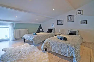 a bedroom with two beds and a rug at Maison de ville moderne climatisée avec piscine in Morières-lès-Avignon
