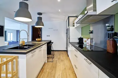 a kitchen with white cabinets and a black counter top at Maison de ville moderne climatisée avec piscine in Morières-lès-Avignon
