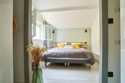 a bedroom with a bed and a vase with flowers at Maison de ville moderne climatisée avec piscine in Morières-lès-Avignon