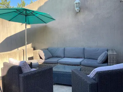 a patio with a blue couch and an umbrella at LA BASTIDE FERREOL in La Motte-dʼAigues