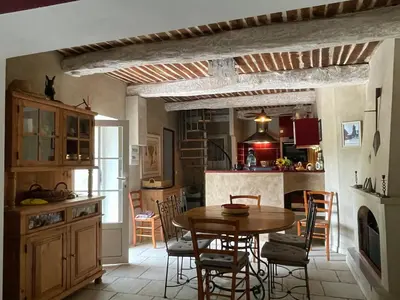 a kitchen and dining room with a table and chairs at LA BASTIDE FERREOL in La Motte-dʼAigues