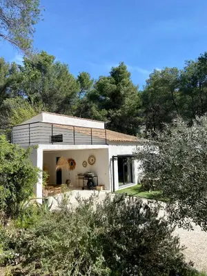a white house with trees in the background at Superbe maison avec jacuzzi in Ventabren