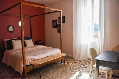 a bedroom with a bed and a table and a window at Mas Gardane in Pernes-les-Fontaines