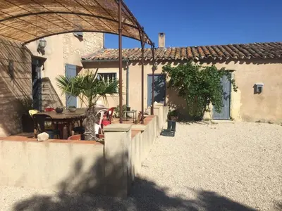 a house with a patio with a table in a yard at Mas Gardane in Pernes-les-Fontaines