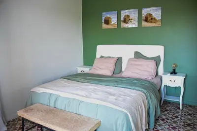 a bedroom with a bed with a green wall at Mas Gardane in Pernes-les-Fontaines