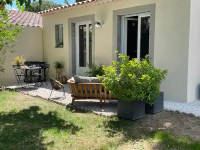 a bench sitting in front of a house with a table at Joli gite en Provence avec piscine in Aubignan