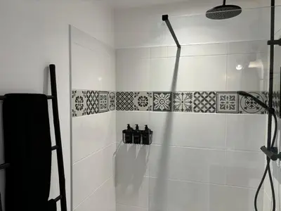 a bathroom with a shower with bottles on the wall at Joli gite en Provence avec piscine in Aubignan