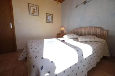 a bedroom with a bed with a white comforter at pretty detached villa with private swimming pool, in Aureille, in the alpilles - 8 people in Aureille