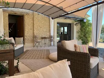 an outdoor patio with wicker chairs and a table at La Bergerie des Pottiers. Mas rénové climatisation Piscine in Crillon-le-Brave