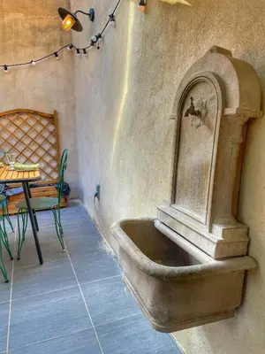 a sink in the corner of a room with a table at Le Petit Delphia in Apt