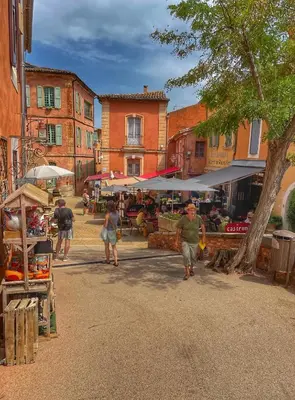 a group of people walking through an outdoor market at Le Petit Delphia in Apt