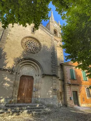 an old church with a wooden door and a tower at Le Petit Delphia in Apt