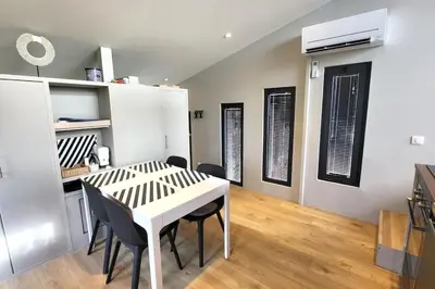 a dining room with a white table and black chairs at LOU BRISOU in Saint-Saturnin-les-Apt