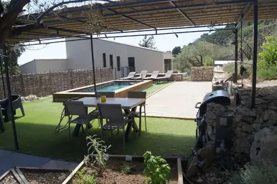 a patio with a table and chairs and a pool at LOU BRISOU in Saint-Saturnin-les-Apt