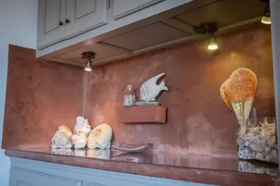 a counter with rocks and other items on a wall at Slpendid villa with heated pool and Jacuzzi for 12 people in Saint-chamas in Saint-Chamas