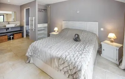 a bedroom with a large bed and a bathroom at Nice Home In La-Roque-Sur-Pernes in La Roque-sur-Pernes