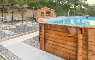 a swimming pool with a wooden deck and a swimming poolvisor at Nice Home In La-Roque-Sur-Pernes in La Roque-sur-Pernes