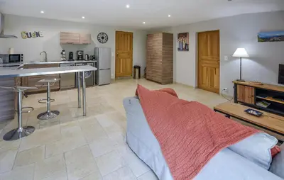 a living room with a couch and a kitchen at Nice Home In La-Roque-Sur-Pernes in La Roque-sur-Pernes
