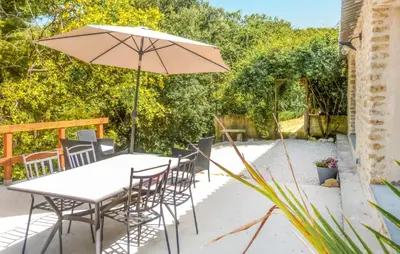 a table and chairs with an umbrella on a patio at Nice Home In La-Roque-Sur-Pernes in La Roque-sur-Pernes