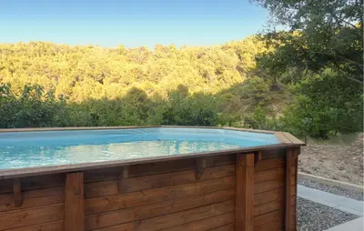 a swimming pool in a wooden deck with a mountain at Nice Home In La-Roque-Sur-Pernes in La Roque-sur-Pernes