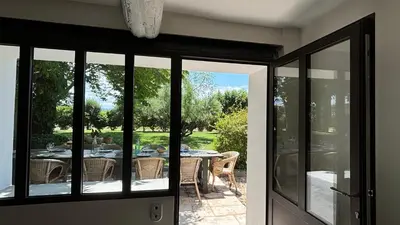 a sliding glass door leading to a patio with a table at Le Mas de Bonnety - Magnifique mas 12 personnes au Pied du Mont Ventoux in Saint-Pierre-de-Vassols