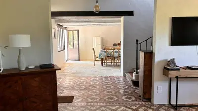 a living room with a television and a dining room at Le Mas de Bonnety - Magnifique mas 12 personnes au Pied du Mont Ventoux in Saint-Pierre-de-Vassols